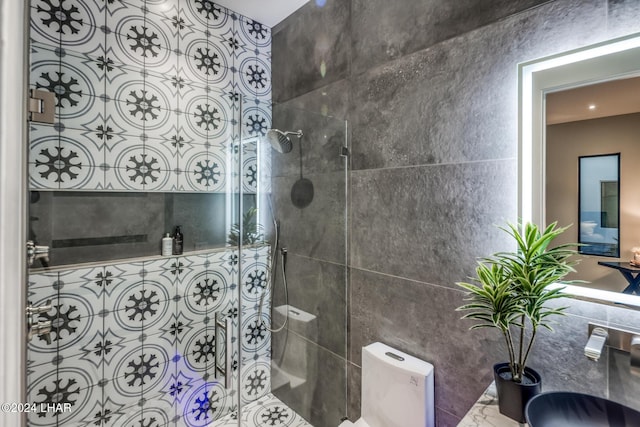 bathroom with tile walls, toilet, and walk in shower