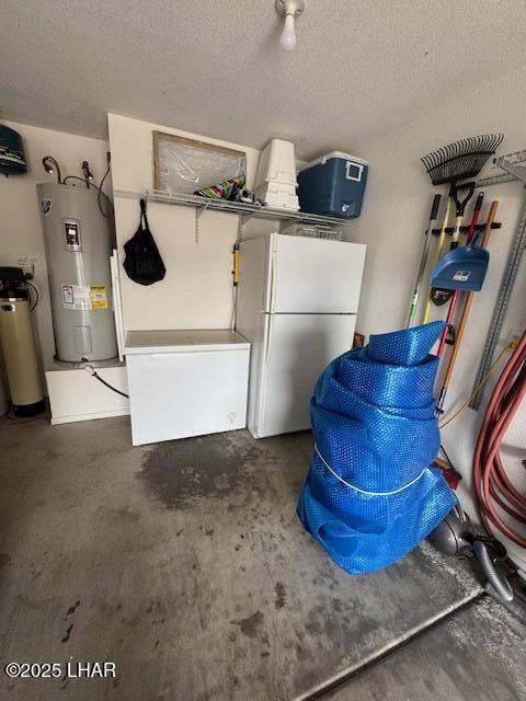 interior space featuring fridge, electric water heater, and freestanding refrigerator