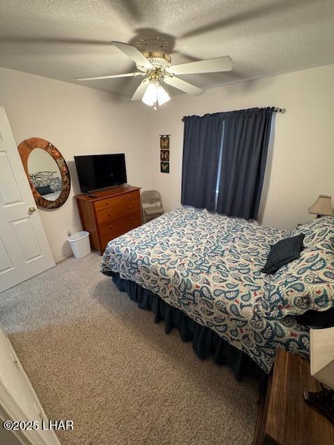 bedroom featuring ceiling fan, a textured ceiling, and carpet