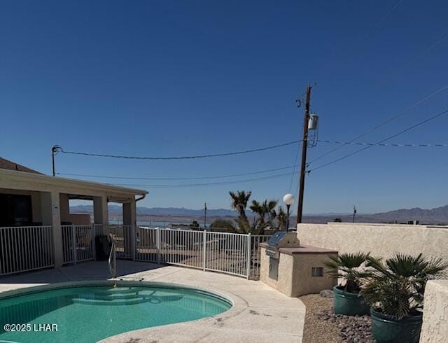 view of pool with a fenced in pool, a mountain view, and a patio