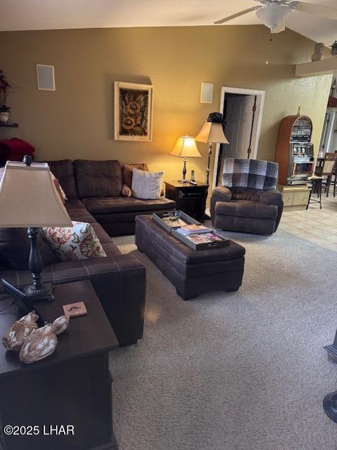 carpeted living area featuring ceiling fan and vaulted ceiling