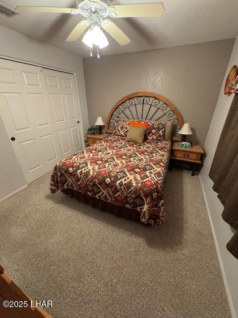 bedroom featuring visible vents, a ceiling fan, a textured ceiling, a closet, and carpet