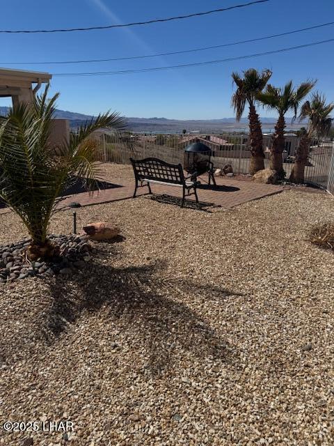 view of yard featuring a mountain view, a patio, and fence