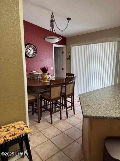 dining room with light tile patterned floors and a textured wall