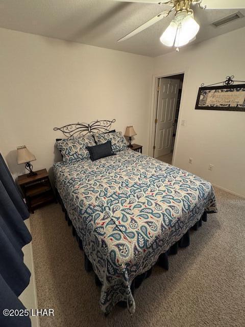 bedroom with visible vents, a ceiling fan, and carpet floors