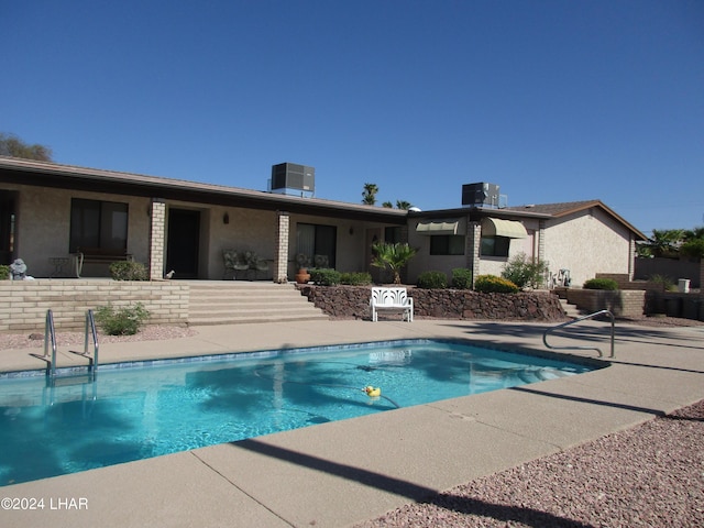 view of pool with central AC and a patio