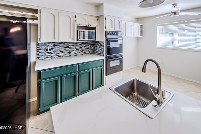 kitchen featuring sink, white cabinets, backsplash, and black appliances