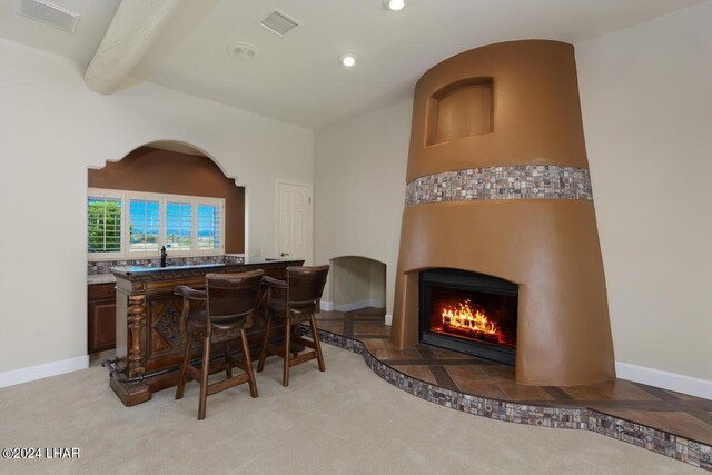 bar with beamed ceiling and light colored carpet