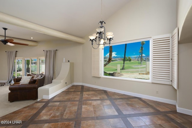 unfurnished dining area with ceiling fan with notable chandelier and high vaulted ceiling