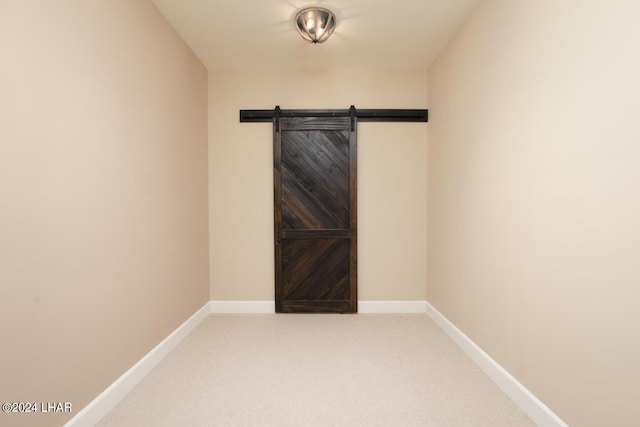 spare room with carpet floors and a barn door