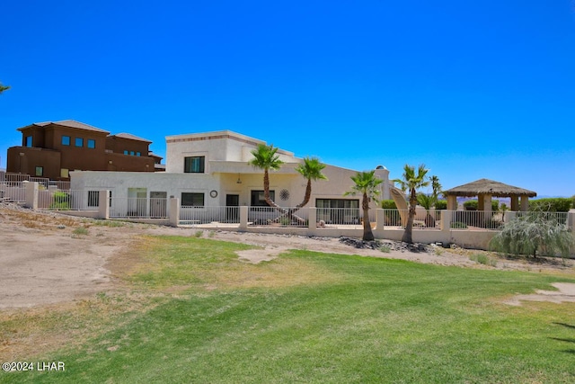 back of property with a gazebo and a lawn