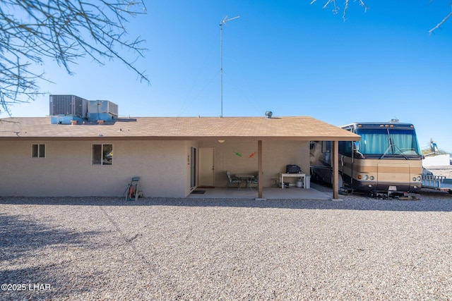 back of house featuring a patio area, central AC unit, and stucco siding