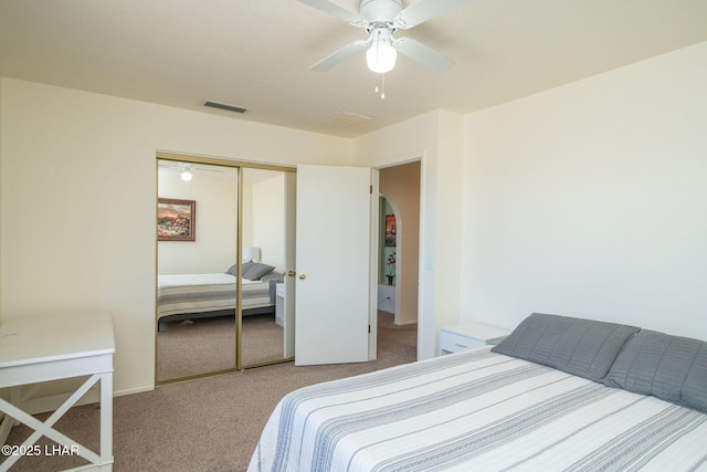 carpeted bedroom with visible vents, a closet, and a ceiling fan