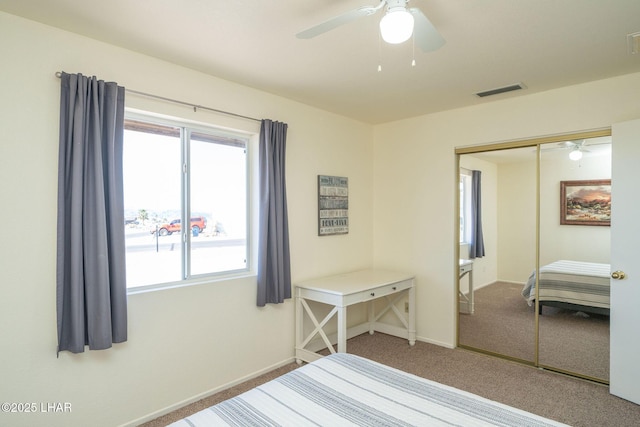 carpeted bedroom featuring a ceiling fan, visible vents, a closet, and baseboards