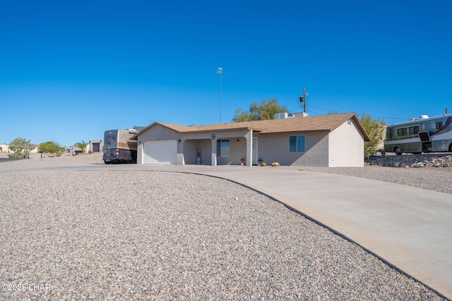 ranch-style house with concrete driveway, a garage, and stucco siding