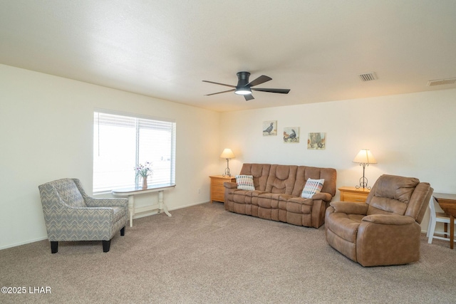 living area featuring visible vents, ceiling fan, and carpet flooring