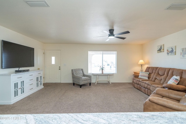 living room with visible vents, carpet flooring, and a ceiling fan