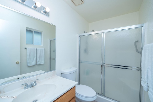 bathroom with toilet, an enclosed shower, and vanity