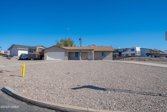 ranch-style house featuring concrete driveway and a garage