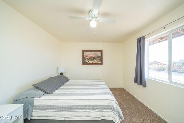 bedroom featuring a ceiling fan, baseboards, and dark colored carpet