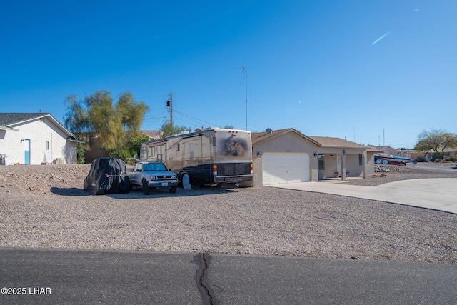 view of front of home featuring stucco siding, concrete driveway, and a garage