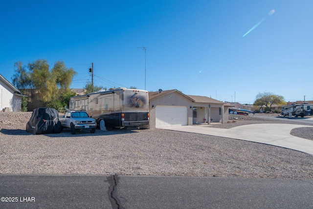 view of front of home with stucco siding, driveway, and an attached garage