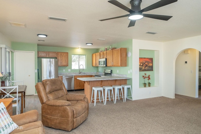 kitchen with a sink, visible vents, appliances with stainless steel finishes, and open floor plan