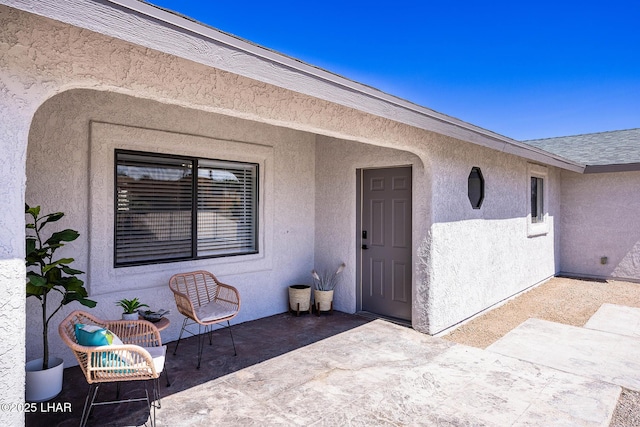 property entrance with a patio and stucco siding