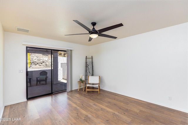unfurnished room featuring visible vents, ceiling fan, wood finished floors, and baseboards