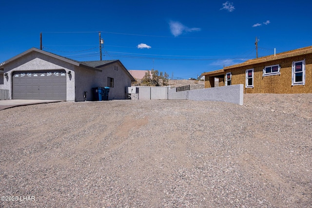 view of yard featuring driveway, fence, and a garage