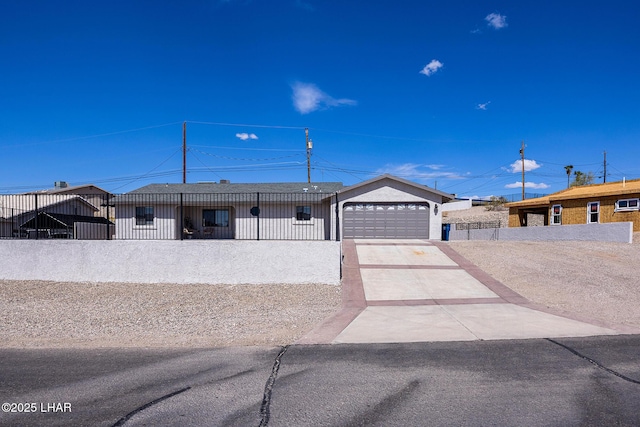 ranch-style house featuring a fenced front yard, a garage, and driveway