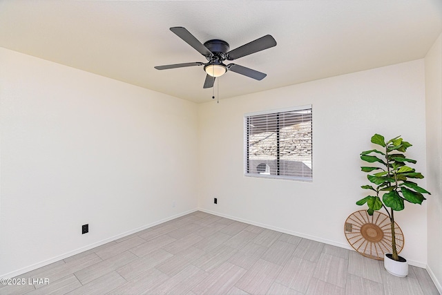spare room with baseboards and ceiling fan
