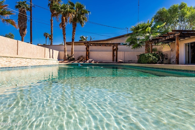 view of pool featuring fence and a pergola