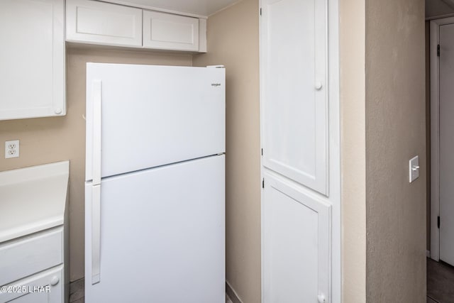 kitchen featuring white cabinetry and white fridge