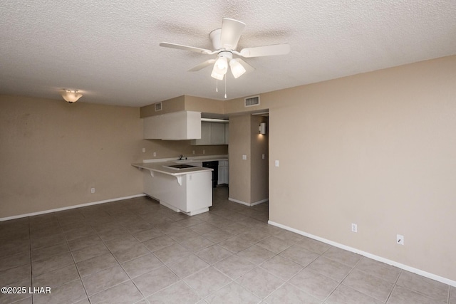 kitchen with white cabinetry, dishwasher, light tile patterned floors, ceiling fan, and kitchen peninsula