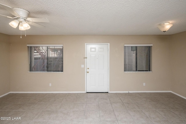 tiled spare room featuring ceiling fan and a textured ceiling