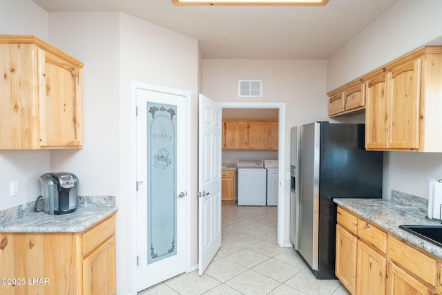 kitchen with separate washer and dryer, stainless steel fridge, and light brown cabinetry