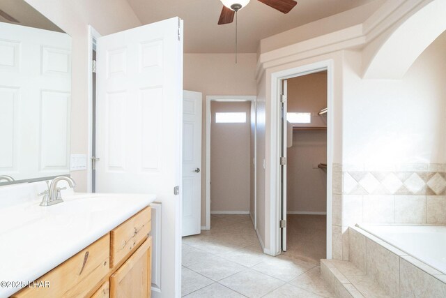 bathroom with vanity, tile patterned flooring, a relaxing tiled tub, and ceiling fan