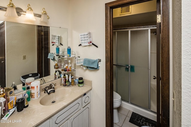 bathroom with vanity, tile patterned floors, toilet, and walk in shower