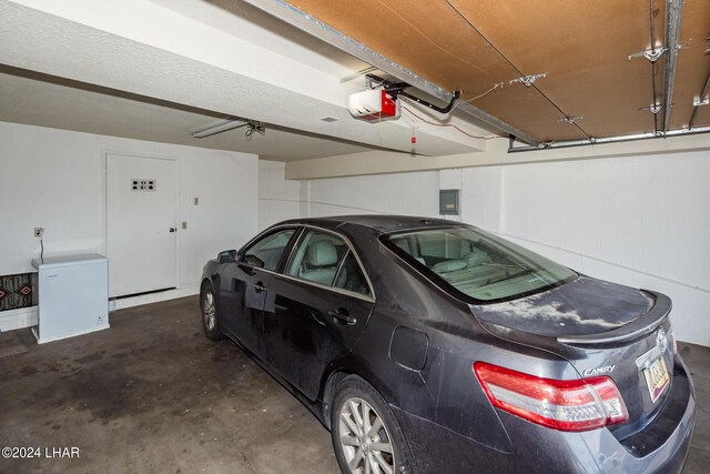 garage with a garage door opener and electric panel