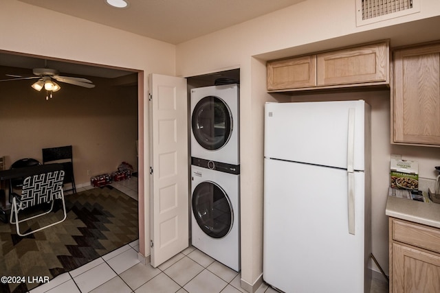 laundry room with stacked washer and dryer, light tile patterned floors, and ceiling fan