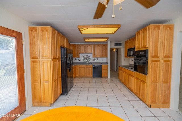 kitchen featuring light tile patterned floors, black appliances, sink, and ceiling fan