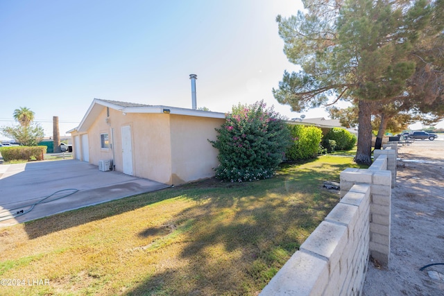 view of side of home featuring a patio area and a lawn