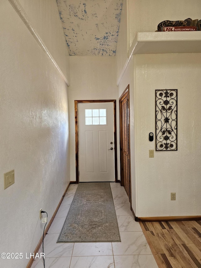 entryway featuring marble finish floor and baseboards