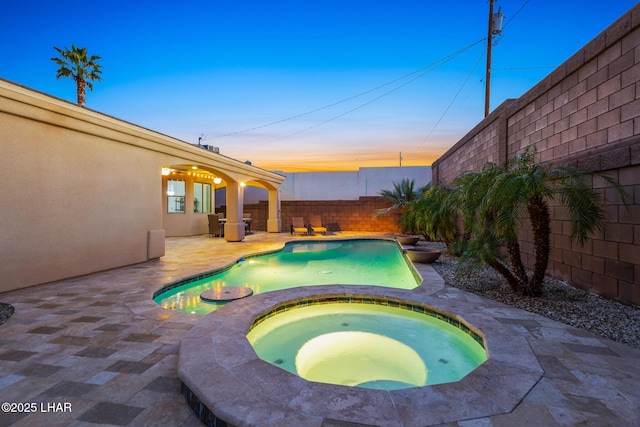 pool at dusk featuring a fenced in pool, a patio, an in ground hot tub, and a fenced backyard