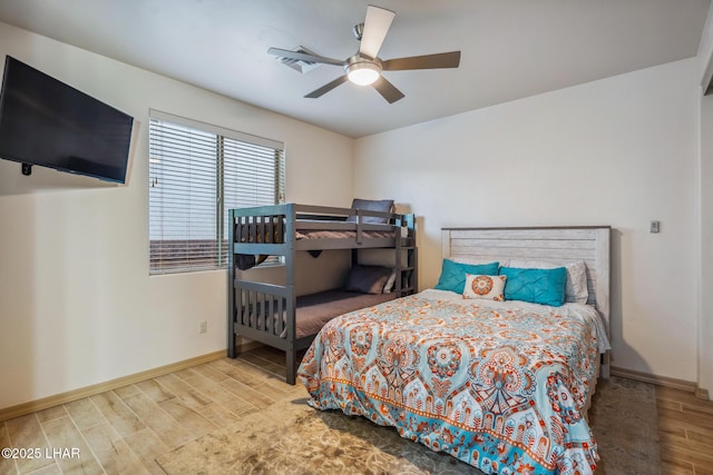 bedroom featuring a ceiling fan, baseboards, and wood finished floors