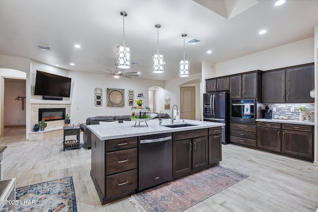 kitchen with arched walkways, visible vents, stainless steel appliances, and a sink