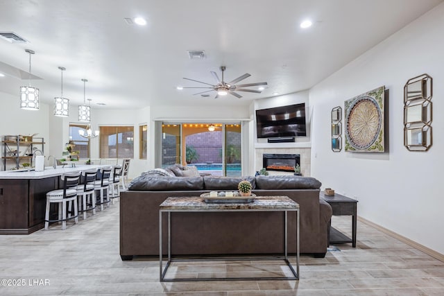 living room featuring recessed lighting, visible vents, and a tile fireplace