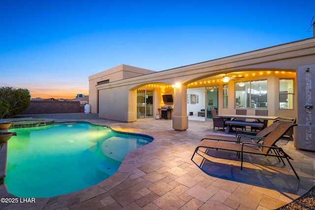 view of swimming pool featuring a patio area, fence, a pool with connected hot tub, and a grill