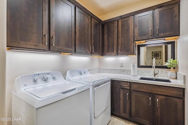 laundry room featuring washer and dryer, cabinet space, and a sink